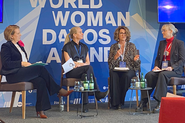 Four women sit on a stage for a panel discussion.