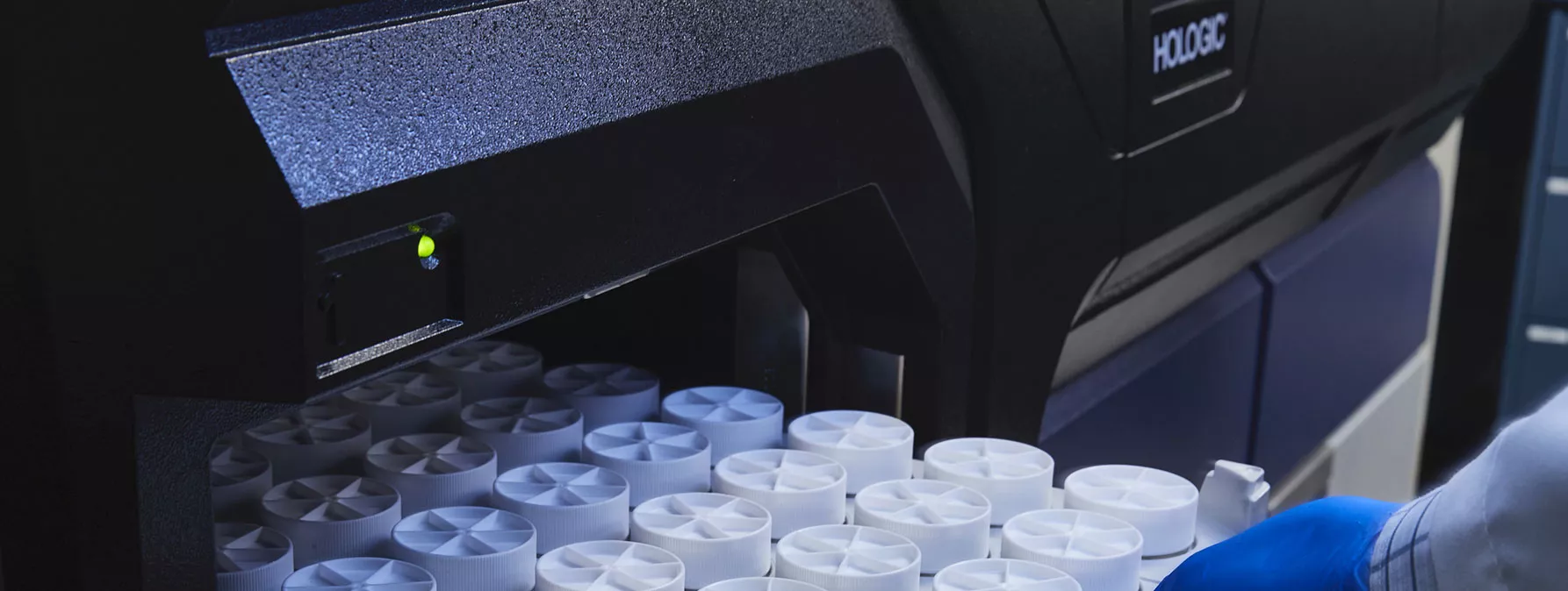 Gloved hand pulling out tray of specimens